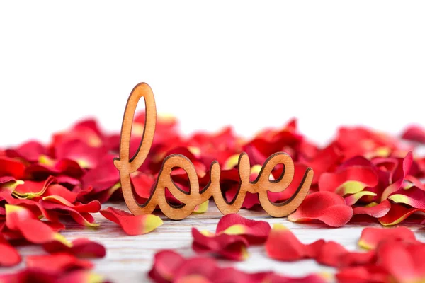 Das Wort Liebe Auf Einem Hintergrund Aus Roten Rosenblättern Mit — Stockfoto