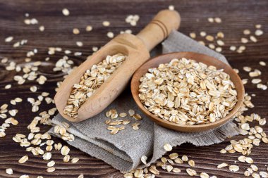 Yulaf ezmesi ya da kâsede yulaf ezmesi ve koyu ahşap masada kepçe.