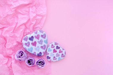 Sevgililer Günü geçmişi. İki kutu pembe kağıtlı arka planda kalpler ve mesajın için yer var. Üst görünüm