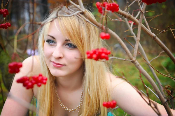 Portret van een mooi meisje in de buurt van de rode planten van viburnum — Stockfoto