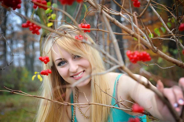 Portret van een mooi meisje in de buurt van de rode planten van viburnum — Stockfoto