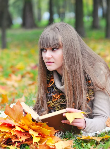 Hermosa chica con libro en el parque de otoño — Foto de Stock