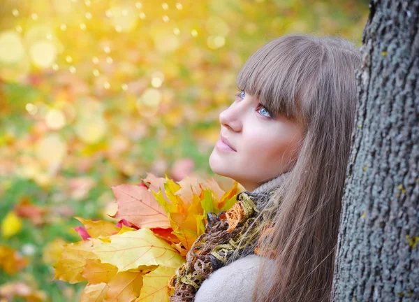 Portrait de belle jeune femme aux feuilles d'automne — Photo