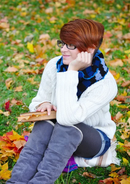 Vacker flicka med bok i höst park — Stockfoto