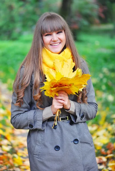 Portrait of beautiful young woman with autumn leaves — Stock Photo, Image