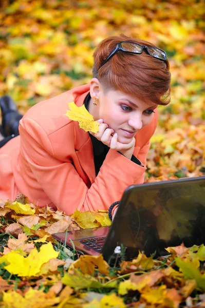 Cute woman with laptop in the autumn park — Stock Photo, Image