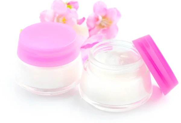 Crèmes cosmétiques et fleurs roses isolées sur fond blanc — Photo