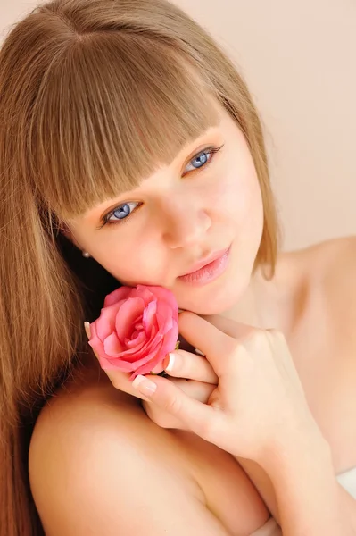 Belle fille avec fleur de rose touchant son visage. Concept de soins de la peau — Photo