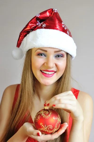 Attractive young woman holding red Christmas ball — Stock Photo, Image