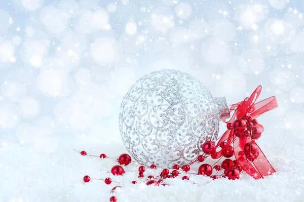 Weihnachten rote und silberne Dekorationen auf Schnee auf festlichem Hintergrund — Stockfoto
