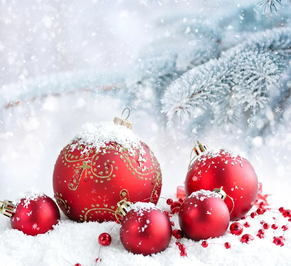 Bolas rojas de Navidad sobre un fondo cubierto de nieve ramas de abeto — Foto de Stock