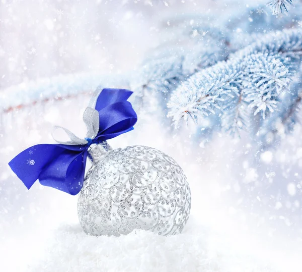 Decorazione d'argento di Natale su uno sfondo rami di abete coperti dalla neve — Foto Stock
