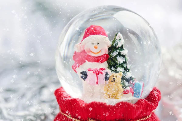 Een sneeuwbol met sneeuwpop op feestelijke achtergrond — Stockfoto