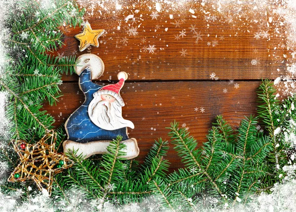 Ramos de abeto com Papai Noel e decorações de Natal em fundo de madeira — Fotografia de Stock