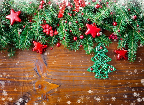 Weihnachtsschmuck aus Christbaumkugeln mit Tannenzweigen auf Holzgrund — Stockfoto