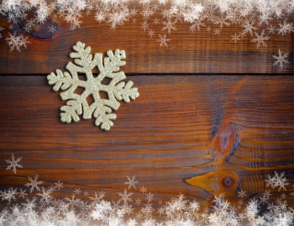 Gold decoration snowflake on a wooden background — Stock Photo, Image