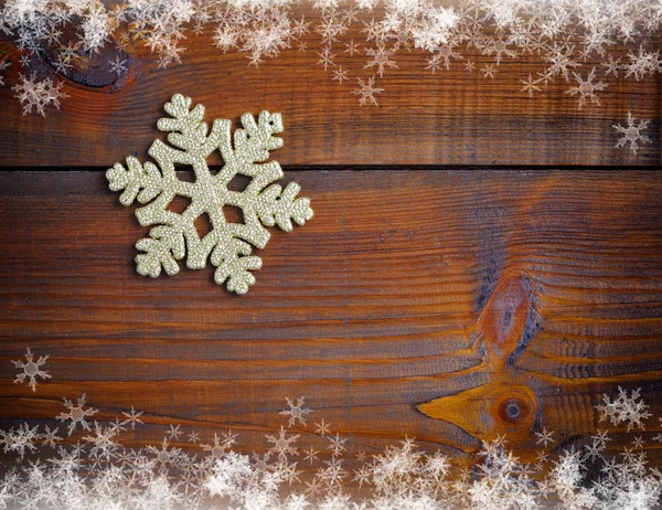 Floco de neve decoração de ouro em um fundo de madeira — Fotografia de Stock