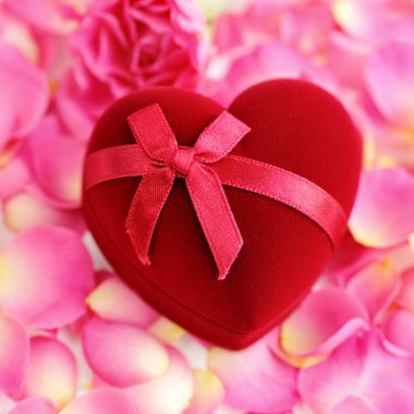 gül yaprakları üzerinde kalp şeklinde hediye kutusu