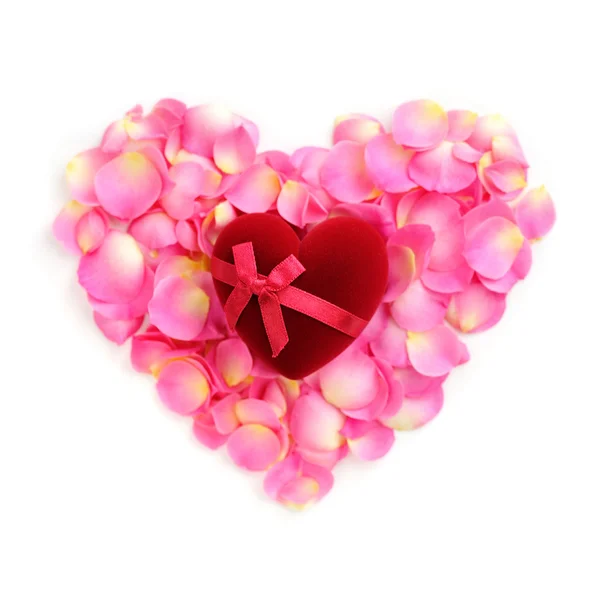 Gül yaprakları üzerinde kalp şeklinde hediye kutusu — Stok fotoğraf