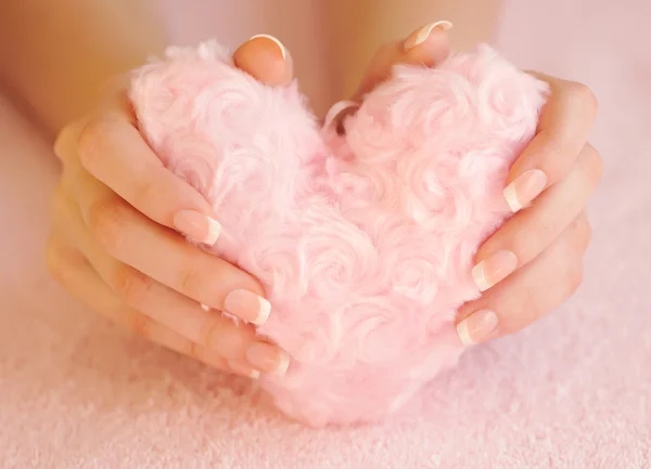 Fell rosa Herz in weiblichen Händen — Stockfoto