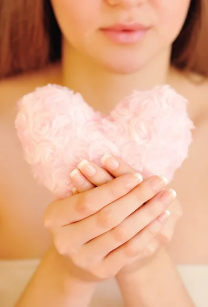 Bundák, rózsaszín szív a női kezek — Stock Fotó