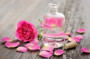 ahşap zemin üzerine gül yaprakları ile uçucu yağ