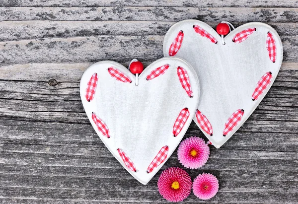 Dos corazones con flores sobre un fondo de madera viejo — Foto de Stock