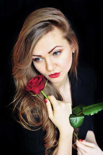 Belle femme avec rose rouge sur fond noir — Photo