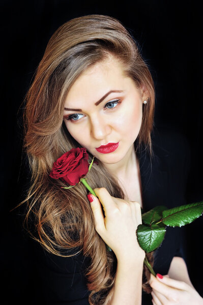 Beautiful woman with red rose on black background