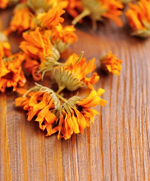 Calêndula flores secas (Calendula officinalis) em um fundo de madeira — Fotografia de Stock