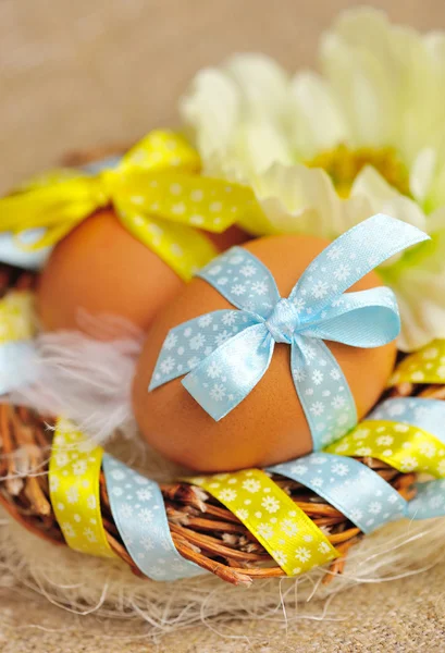 Пасхальные яйца на венке на фоне льняной ткани — стоковое фото