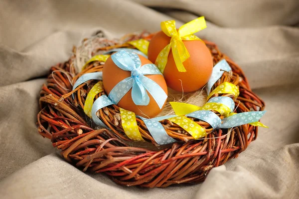 Easter eggs in the nest on a burlap — Stock Photo, Image