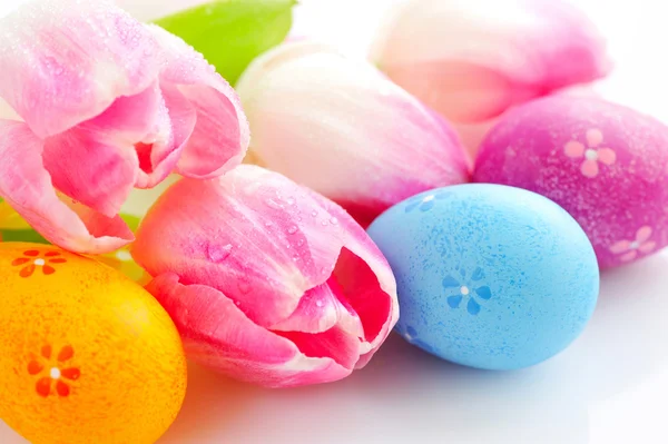 Easter eggs with pink tulip flowers on white background — Stock Photo, Image