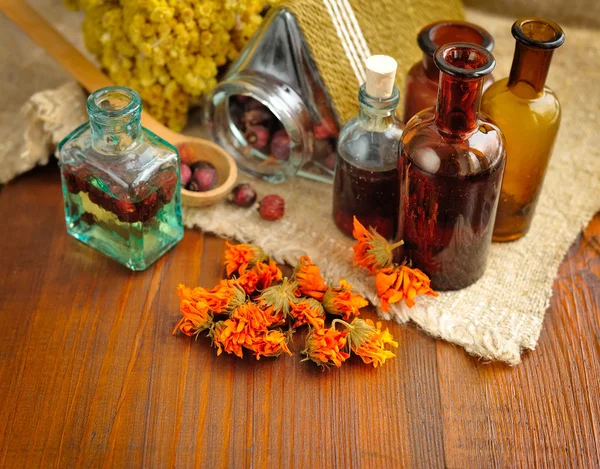 Ervas curativas e tinturas em garrafas em pano de saco, flores secas, fitoterapia — Fotografia de Stock