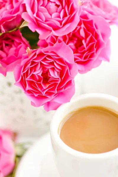 Tassen Kaffee und rosa Rosen auf weißem Hintergrund — Stockfoto