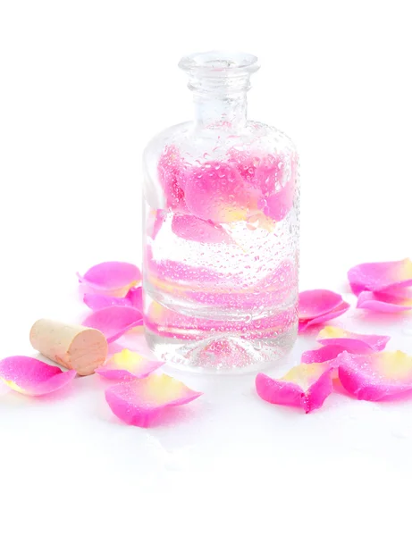 Bottle of essential oil and petal pink rose isolated on white — Stock Photo, Image