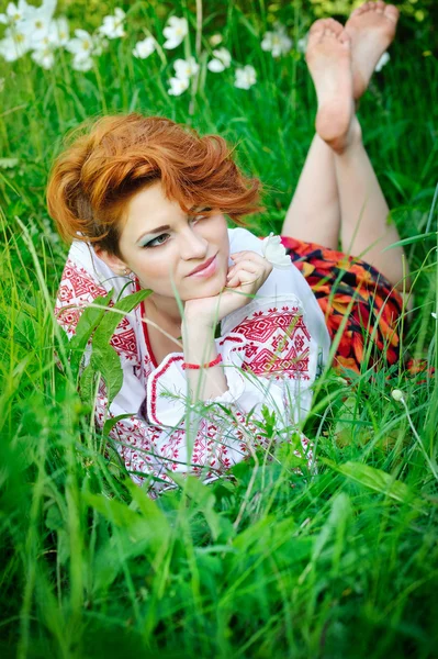 Jeune belle femme dans le costume national ukrainien dans la prairie à fleurs — Photo