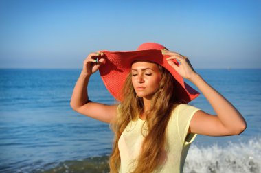 Deniz bir arka plan üzerinde şapkalı güzel kız