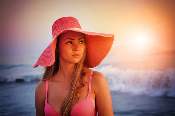 Beautiful girl in a hat on a background of sea sunset — Stock Photo, Image