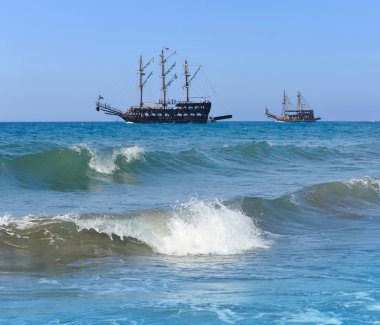 eski gemiler mavi su üzerinde yelken. kıyıdan görüntülemek