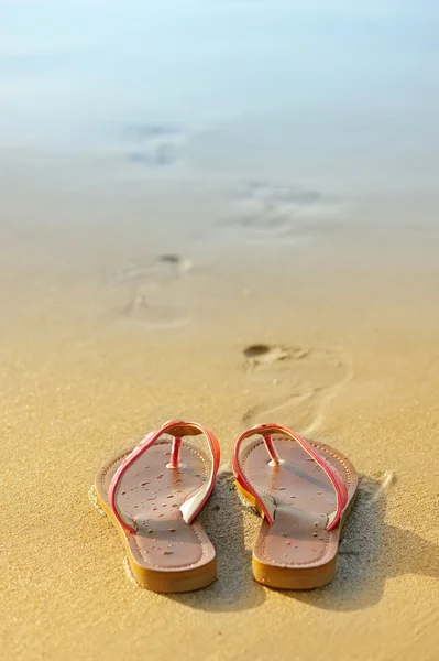 Καλοκαιρινή έννοιας διακοπές. σαγιονάρες σε μια αμμώδη ωκεανό παραλία — Φωτογραφία Αρχείου