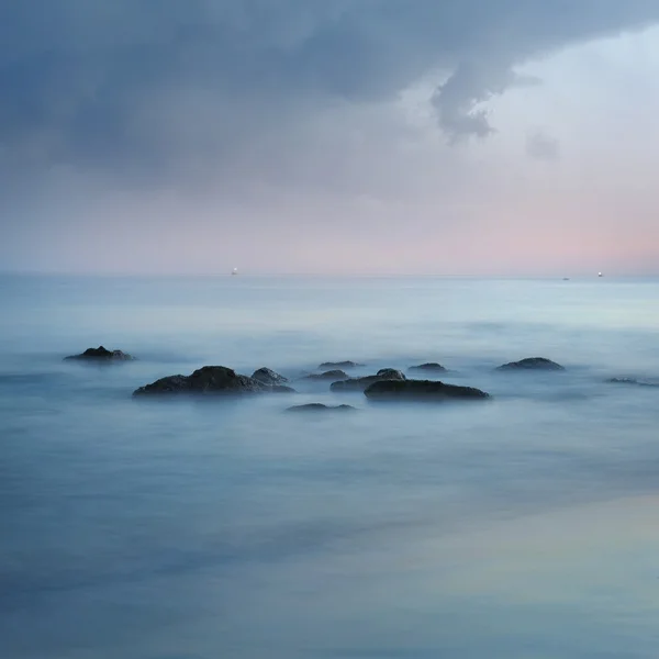 Minimalistische neblige Meereslandschaft mit Felsen bei langer Belichtung — Stockfoto