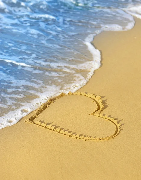 Wave washes over heart in the sand — Stock Photo, Image