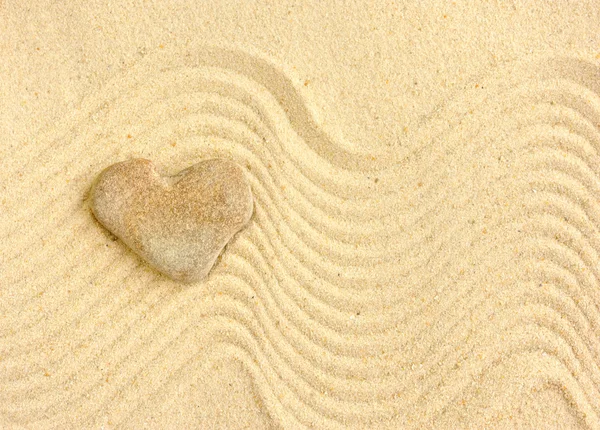 Herzförmiger Stein liegt auf Sand — Stockfoto