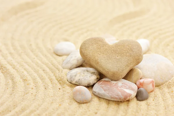 Herzförmiger Stein liegt auf Sand — Stockfoto