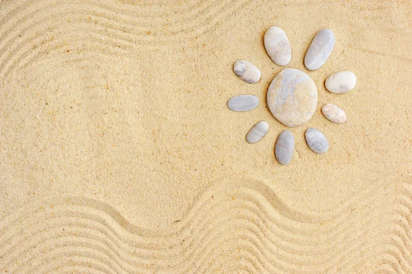 Stenen gerangschikt als een zon op het strand — Stockfoto