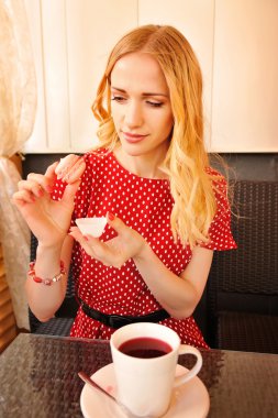 Güzel sarışın kadın çay partisi yaparken acıbadem kurabiyesi yeme. Sh