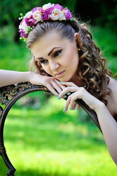 Belle jeune femme dans une couronne avec miroir vintage à l'extérieur — Photo