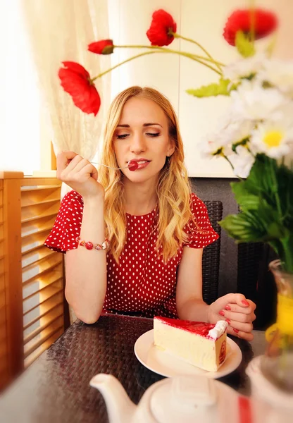 Mooie blonde vrouw eten een kers op de taart. Schot in de c — Stockfoto