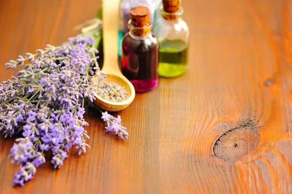 Lavendelblüten und Lavendelöl auf Holzgrund — Stockfoto